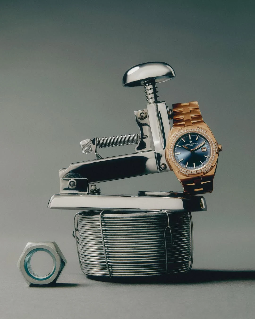 A luxury watch displayed with precision metal tools